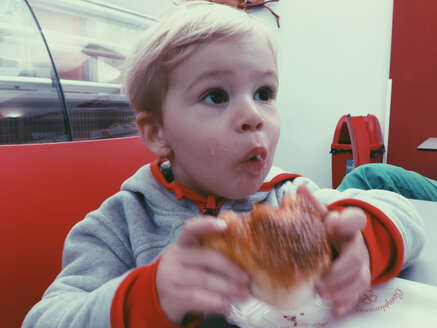 Young boy eating a bun in a restaurant of Palermo, Sicily, Italy - MEAF000081