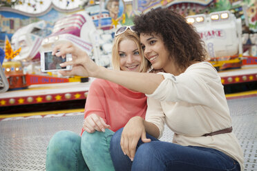 Germany, Herne, Two young women at the fairground photographing self - BGF000070