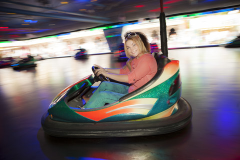 Germany, Herne, Two young women riding bumper cars at the fairground stock photo