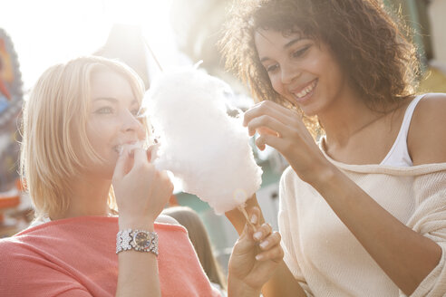 Deutschland, Herne, Zwei junge Frauen auf dem Rummelplatz essen Zuckerwatte - BGF000081