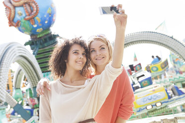 Germany, Herne, Two young women at the fairground photographing self - BGF000058