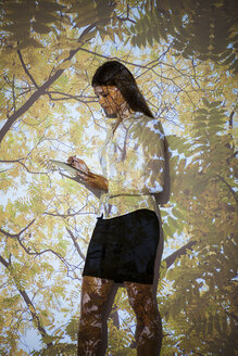 Junge Frau in Naturprojektion mit digitalem Tablet - BGF000084