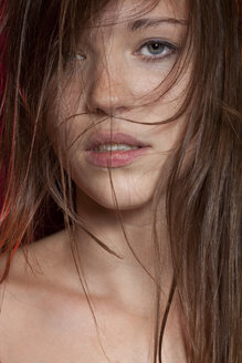 Young woman with strands of hair, close up - BGF000053