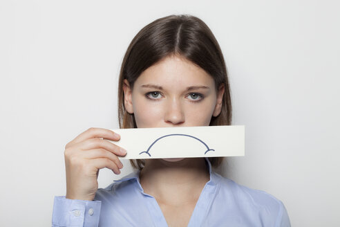 Young woman covering part of face with painted sad mouth - BGF000051