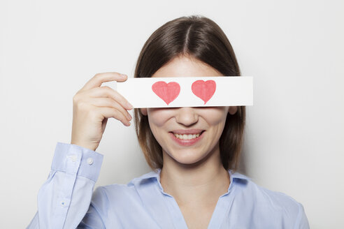 Young woman covering part of face with painted hearts - BGF000050