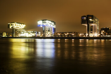 Germany, North Rhine-Westphalia, Cologne, Crane houses at Rheinau harbour at night - JATF000557