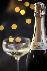 https://us.images.westend61.de/0000311016j/champagne-glass-and-bottle-in-front-of-lights-close-up-SBDF000456.jpg