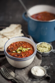 Tortillas und Schalen mit Guacamole, saurer Sahne und Chili con Carne auf dem Holztisch - SBDF000460