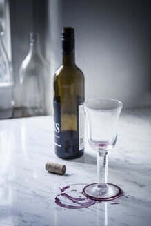Leeres Rotweinglas, Flaschen, Flecken und Weinkorken auf weißem Marmor - SBDF000473