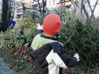 Kleiner Junge winkt dem Weihnachtsbaum zum Abschied zu - ZMF000094