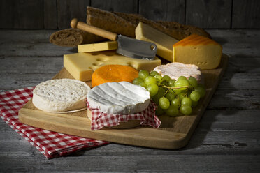 Cheese platter, different cheese, french cheddar, french soft cheese, french sheep cheese, camembert, emmentaler, and austrian mountain cheese and wholemeat baguette on wooden board - MAEF007646