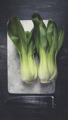 Zwei Pak Choi (Brassica rapa chinensis, Senfkohl) auf Holzbrett mit Messer, Atelier - SBDF000475