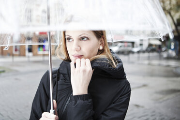 Junge Frau hält transparenten Regenschirm - FEXF000053
