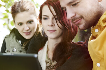 Drei Freunde benutzen ein digitales Tablet - FEXF000056
