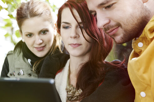 Three friends using digital tablet - FEXF000056