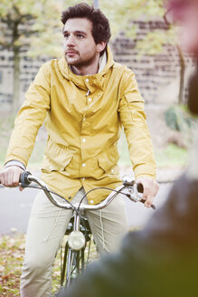 Germany, North Rhine-Westphalia, Cologne, young man sitting on bicycle - FEXF000068