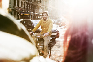 Germany, North Rhine-Westphalia, Cologne, young man riding bicycle - FEXF000072