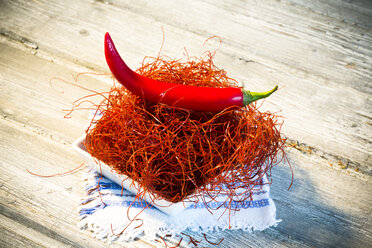 Bowl of red chili pepper and chili threads on dolly and wooden table - MAEF007654