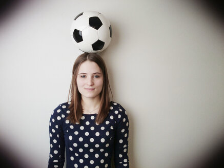 Junge Frau mit einem Fußball auf dem Kopf - JATF000595