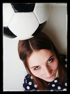 Junge Frau mit einem Fußball auf dem Kopf - JATF000596