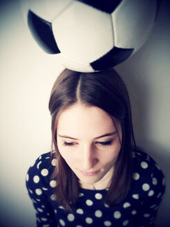 Junge Frau mit einem Fußball auf dem Kopf - JATF000613