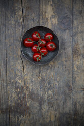 Schale mit Kirschtomaten auf Holztisch, Blick von oben - LVF000473