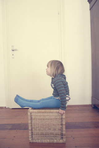 Little girl sitting on a basket stock photo