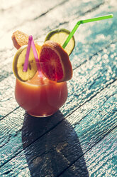 Glass of multivitamine juice decorated with slices of limes, lemon, orange and blood orange on table - SARF000208