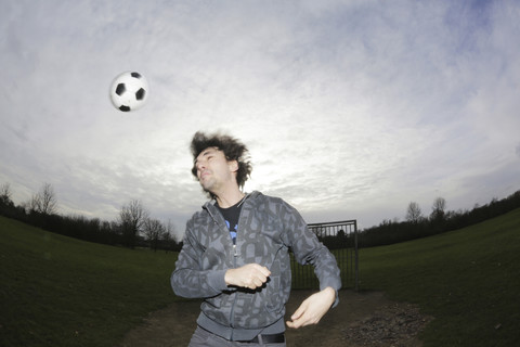 Young man heading a football stock photo