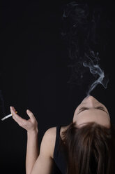 Junge Frau mit Zigarette beim Staubblasen - BFRF000329