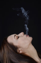 Young woman blowing dust - BFRF000330