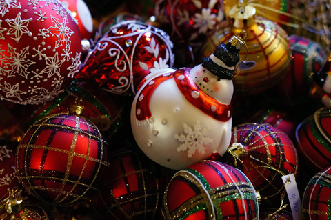 Sammlung verschiedener Weihnachtskugeln, eine davon in Form eines Schneemanns, lizenzfreies Stockfoto