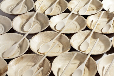 Many palm leaf plates with wooden spoons, studio shot - CSF020682
