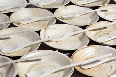 Many palm leaf plates with wooden spoons, studio shot - CSF020734