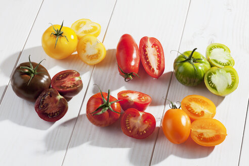 Verschiedene geschnittene Tomaten auf einem Holztisch - CSF020672