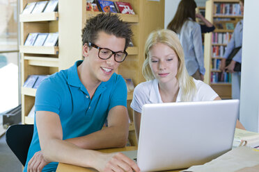 Deutschland, Baden-Württemberg, Studenten mit Laptop lernen in einer Bibliothek - CHAF000113
