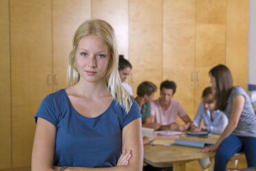 Deutschland, Baden-Württemberg, Porträt einer jungen Studentin und ihrer Klassenkameraden im Hintergrund - CHAF000098