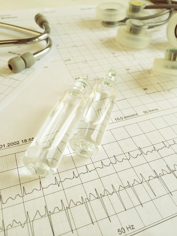 Ruhe-EKG mit Stethoskop und Ampullen, EKG zeigt eine absolute Arrhythmie bei Vorhofflimmern, Freiburg, Deutschland, lizenzfreies Stockfoto