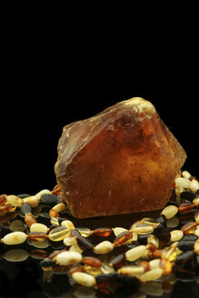 Raw amber and amber necklace in front of black background - JAWF000002