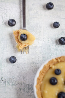 Zitronenkuchen mit Blaubeeren auf weißem Holztisch - SBDF000497