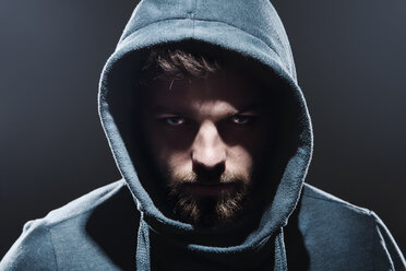 Portrait of man with hooded jacket in front of dark grey background - PD000618