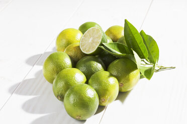 Limes and leaves on wooden table - CSF020743