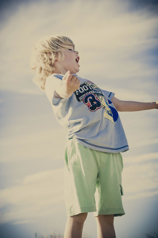 Blond boy screaming outdoors stock photo