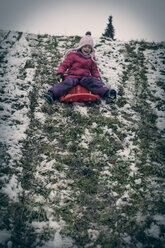 Germany, Bavaria, Landshut, laughing little girl tobogganing - SARF000222