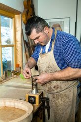 Gitarrenbauer in seiner Werkstatt - TC003859