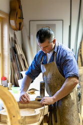 Gitarrenbauer in seiner Werkstatt - TC003840