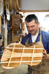 Gitarrenbauer in seiner Werkstatt - TC003847