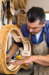 Gitarrenbauer in seiner Werkstatt - TC003861