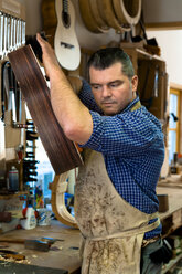 Gitarrenbauer in seiner Werkstatt - TC003876
