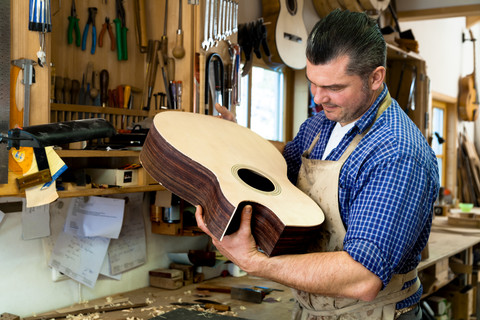 Gitarrenbauer in seiner Werkstatt, lizenzfreies Stockfoto